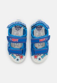 Sandales bleues pour enfants avec des sangles "Puppy", logo Paw Patrol à l'intérieur, et motifs d'étoiles et d'os rouges, blancs et bleus. Taille 25.