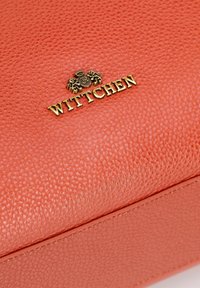 Lśniąca torebka ze skórzanym koralem o fakturze, z gładkim wykończeniem, z złotym logo "WITTCHEN" oraz tłoczeniem przedstawiającym lwy.