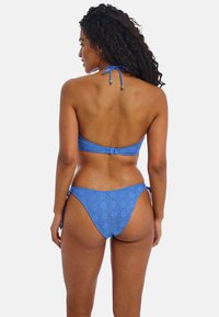 Blue bikini with a textured pattern, featuring a halter neck design and adjustable tie straps. The bottoms have a classic cut with side ties.