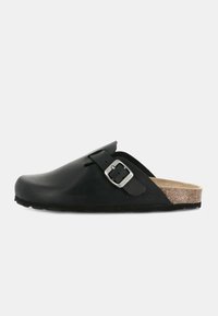 Zoccolo nero realizzato in materiale simile alla gomma con un plantare in sughero. Presenta una larga cinghia con fibbia metallica e una suola testurizzata.