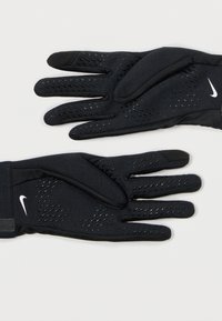 Fekete kesztyűk texturált dizájnnal, szilikon tapadású részletekkel az ujjakon és Nike logóval a csuklón.