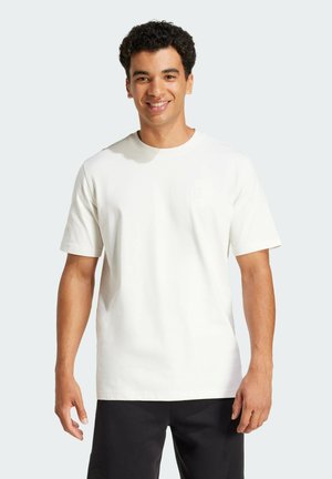 Witte katoenen T-shirt met korte mouwen, met een subtiel logo op de borst. Gladde textuur, standaard ronde halslijn en een relaxte pasvorm.
