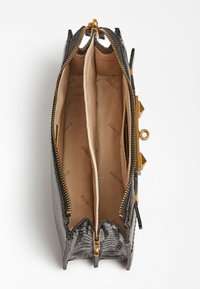 Musta krokotiilikuviollinen käsilaukku, jossa on kultaiset metalliosat, kaksi lokeroa ja vaalea vuori, jossa on toistuva merkkiteksti.