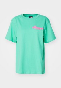 Mintvihreä lyhythihainen T-paita, jossa on vaaleanpunainen "ellesse since 1959" -logo vasemmassa rinnassa. Tässä paidassa on pyöreä kaula-aukko ja rento istuvuus.