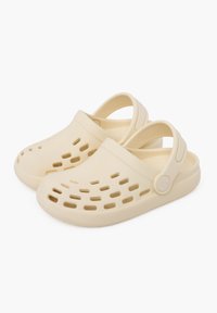 Zoccoli beige realizzati in materiale leggero, dotati di fori di ventilazione, cinturino posteriore e suola texturizzata per una migliore presa. Finitura della superficie liscia.