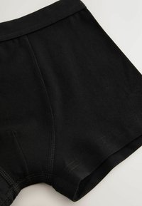 Čierne bavlnené boxerky s elastickým pásom, s hladkým povrchom a plochými švami pre pohodlie. Jednoduchý dizajn bez vzorov.