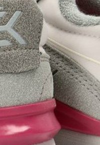 Zapatillas deportivas grises con una parte superior de textura ante, que cuentan con una suela translucida rosa, acentos en blanco y un diseño cosido en el lateral.