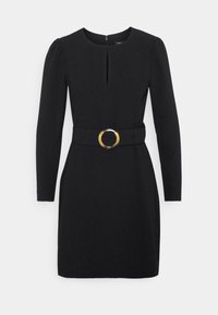 Černé šaty s dlouhými rukávy, kulatým výstřihem, pasovým pásem s kulatou zlatou sponou a středním rozparkem pro detail.