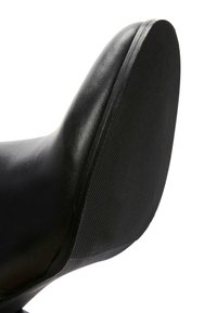 Black leather shoe with a textured rubber sole and rounded toe, featuring a smooth finish on the upper and a patterned outsole.