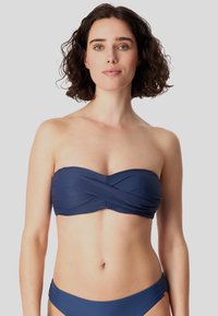 Navyblauwe bandeau-bikini top van textuurstof, met een gedraaide ontwerp in het midden en een bijpassende bikini onderkant. Minimale hardware accenten.