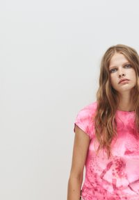 Kortærmet, pink tie-dye T-shirt med rund halsudskæring og livlige mønstre. Blødt stof giver et afslappet udseende.