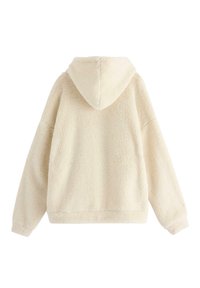 Cream-colored hoodie made of soft, fluffy material, featuring a large hood and long sleeves, with a relaxed fit and no visible fastenings.