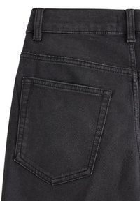 Svarta denimjeans med en bakficka, med en slät textur och kontrasterande sömmar längs sömmarna. Klassisk femficksdesign.