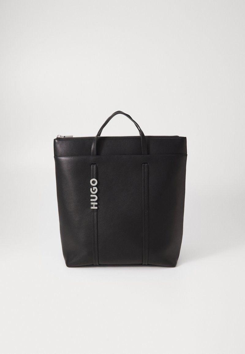 Borsa tote in pelle nera con chiusura a zip, due manici superiori e logo "HUGO" in rilievo sulla parte anteriore. Texture liscia e design strutturato.