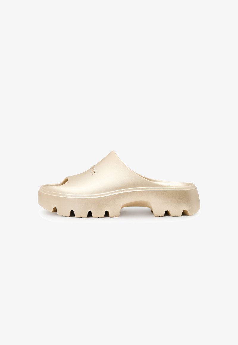 Goldene Slipper mit offenem Zehenbereich, strukturiertem Gummisohle und runden Ausschnitten am Rand. Glatte Oberfläche, modernes Design.