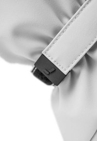 Weißer Stoff mit strukturierter Oberfläche, ausgestattet mit einer schwarzen Hardware-Schnalle und einem flachen Riemen. Das Design ist modern und zeichnet sich durch klare Linien aus.