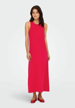 Robe longue sans manches de couleur rose vif, confectionnée en tissu lisse. Elle présente une coupe décontractée et tombe jusqu'aux chevilles, accompagnée de chaussures rouges et brillantes.