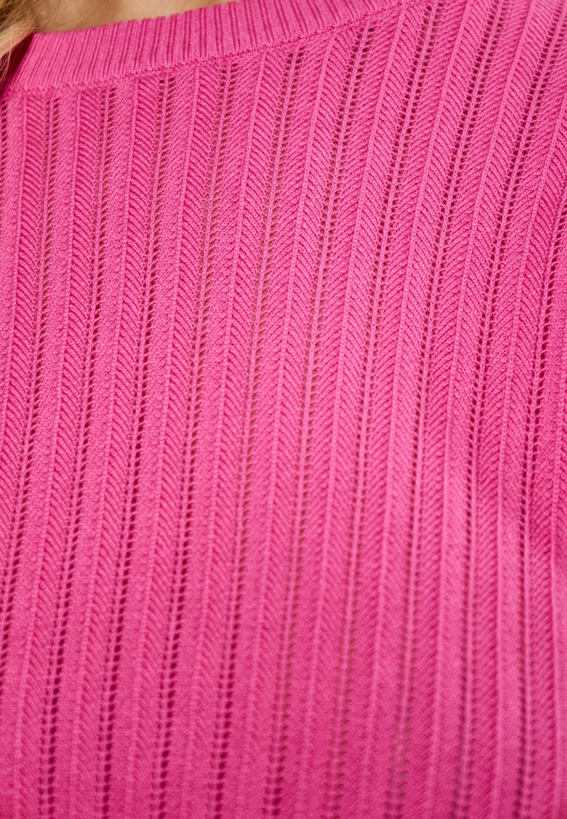 Roze gebreide top met een gestructureerd patroon van verticale strepen, een ronde halslijn en een iets losse pasvorm.