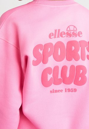 Różowa bluza z dużym, wypukłym napisem "ellesse SPORTS CLUB since 1959" na plecach w ciemniejszym różowym kolorze.