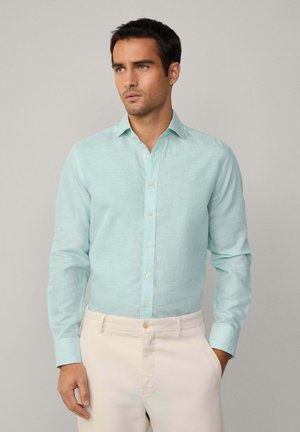 Light turquoise button-up shirt with a fine striped pattern, long sleeves, and a collar, paired with cream-colored trousers.