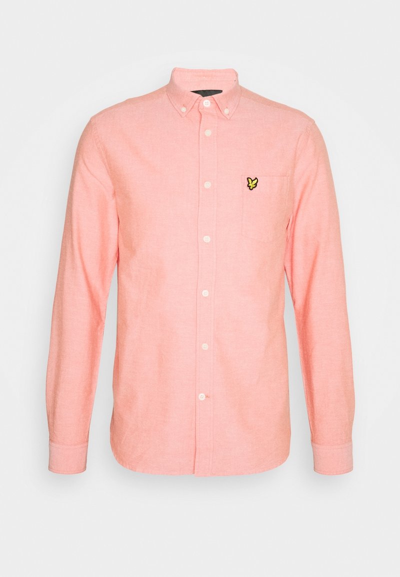Overhemd met lange mouwen in zachtroze stof. Heeft een klein geel vlinderlogo op het linkerborstzakje. Button-down kraagontwerp.