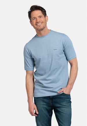 Light blue short-sleeve t-shirt made of soft fabric, featuring a left chest pocket with subtle branding, complemented by dark denim jeans.