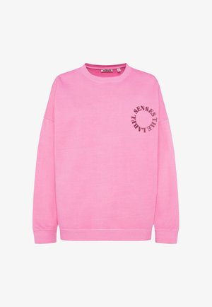 Rosa Sweatshirt aus weichem Baumwollstoff. Mit Rundhalsausschnitt, langen Ärmeln und einem kreisförmigen Grafikdesign mit Text auf der linken Brust.