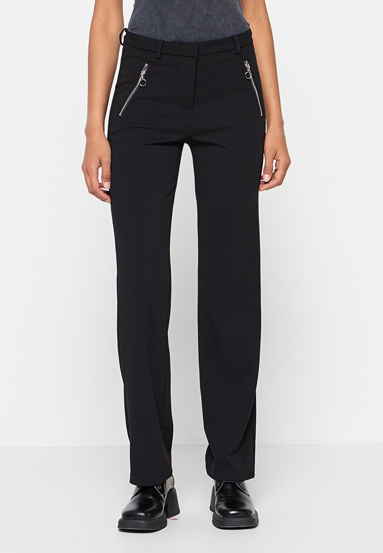 Pantalons noirs ajustés avec une texture lisse, dotés de poches zippées à l'avant et d'une coupe droite.