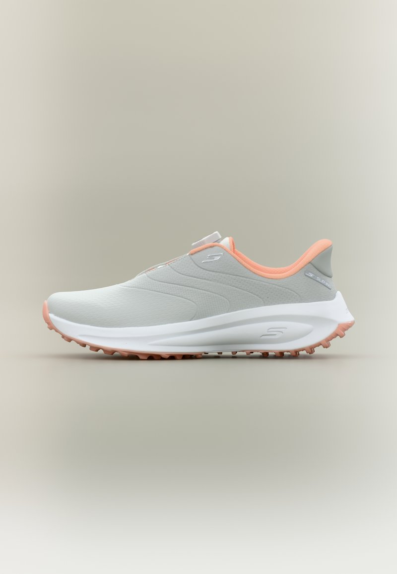Chaussure de sport avec une tige gris clair ornée d'un accent orange, une texture lisse, un design sans lacets et une semelle blanche antidérapante.