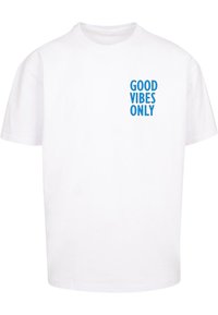 Hvid bomulds T-shirt med rund hals og korte ærmer, med blå tekst der står "GOOD VIBES ONLY" trykt på forsiden.