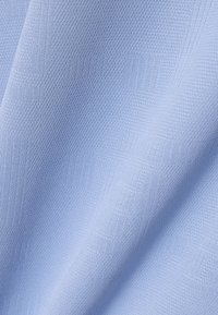 Tela azul claro con un sutil patrón de cuadrados texturizados y un tejido de malla fina, mostrada con pliegues suaves y una iluminación tenue.