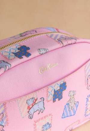 Pungă cosmetică din material textil roz, cu fermoar aurit. Are ilustrații cu diferite rase de câini pe o suprafață texturată, cu un logo gravat în aur.