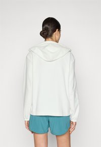 Witte hoodie met een relaxte pasvorm, zachte textuur en een kangoeroezak, gecombineerd met teal shorts. Eenvoudig en modern ontwerp.