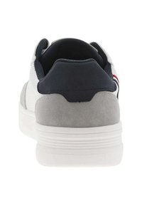 Baskets blanches et grises avec un talon et une languette de talon bleu marine, un dessus texturé, une semelle lisse et de subtils rayures rouges.