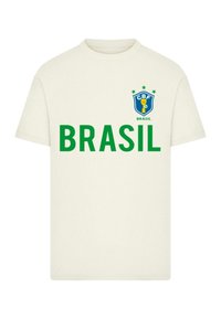 Balta medvilnė marškinėliai su žaliais užrašais "BRASIL" ir mėlynu ženklu su taure ir žvaigždėmis viršuje, esantis kairiajame krūtinės šone.