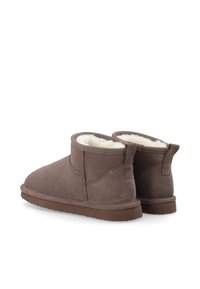 Stivaletti alla caviglia in suede marrone con morbida fodera color crema, punta arrotondata e linguetta sul retro. Suole in gomma offrono trazione e durata.
