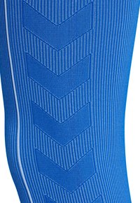 Blått texturerat tyg med vertikala ränder och ett chevronmönster sydd längs en vit vertikal linje.