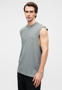 Ανοιχτό γκρι αμάνικο βαμβακερό t-shirt με στρογγυλή λαιμουδιά. Διαθέτει διακριτικό λογότυπο ALLSAINTS στο στήθος. Ομαλή υφή, άνετη εφαρμογή.