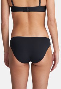 Schwarzer Bikiniunterteil aus einem glatten, dehnbaren Material mit einem tiefen Schnitt. Verfügt über klare Linien und keine sichtbaren Muster oder Beschläge.