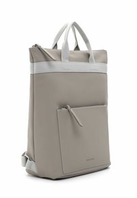 Rechteckiger taupefarbener Rucksack mit vorderer Reißverschlusstasche, weißen Stoffgriffen und verstellbaren Schultergurten, aufrecht stehend vor weißem Hintergrund.