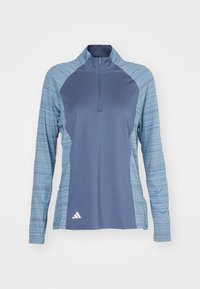 Long-sleeve athletic top in dark blue with light blue striped sleeves, half-zip collar, and a white logo on the lower left.