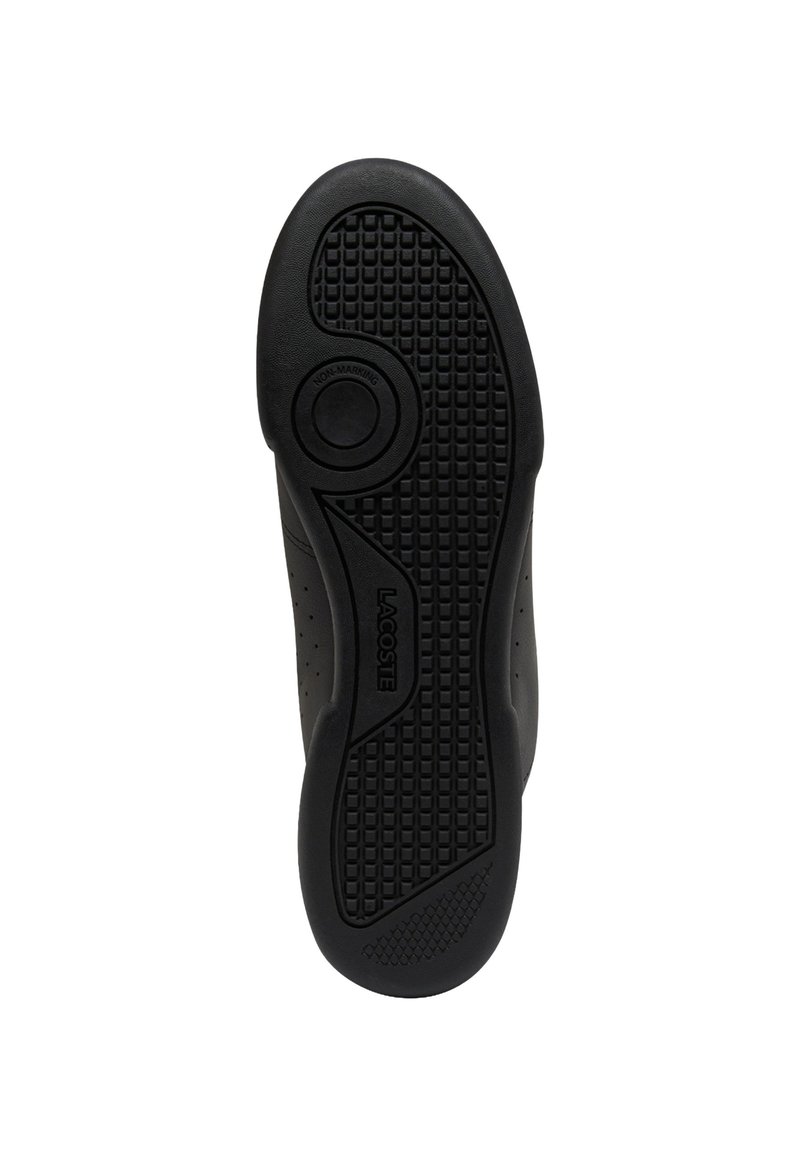 Semelle de basket en caoutchouc noir avec une surface texturée antidérapante, présentant un talon arrondi et un logo circulaire sur la semelle intermédiaire ; design non marquant.