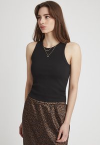 Top noir à rayures avec un design sans manches, associé à une jupe à imprimé léopard brun. La tenue présente une silhouette ajustée et une texture lisse.