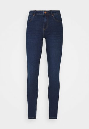 Jeans ajustados de color azul oscuro, hechos de denim, con una cintura alta, cinco bolsillos y costuras en dorado que contrastan a lo largo de las costuras.