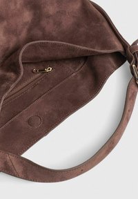 Brun ruskinds skuldertaske med en åben klap, der viser en lynlås inderside lomme og en magnetisk knaplukning indeni.