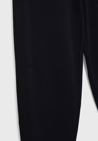 Czarne spodnie materiałowe o slim fit, gładkiej fakturze i dyskretną boczną kieszenią. Prosty design z czystymi liniami i bez widocznych elementów metalowych.