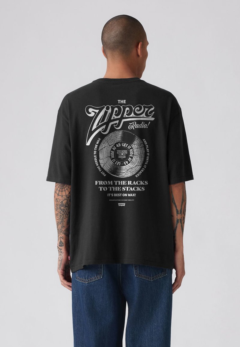 Zwart T-shirt met korte mouwen, voorzien van een grafisch ontwerp met tekst en een illustratie van een vinylplaat op de achterkant. Gemaakt van katoen.