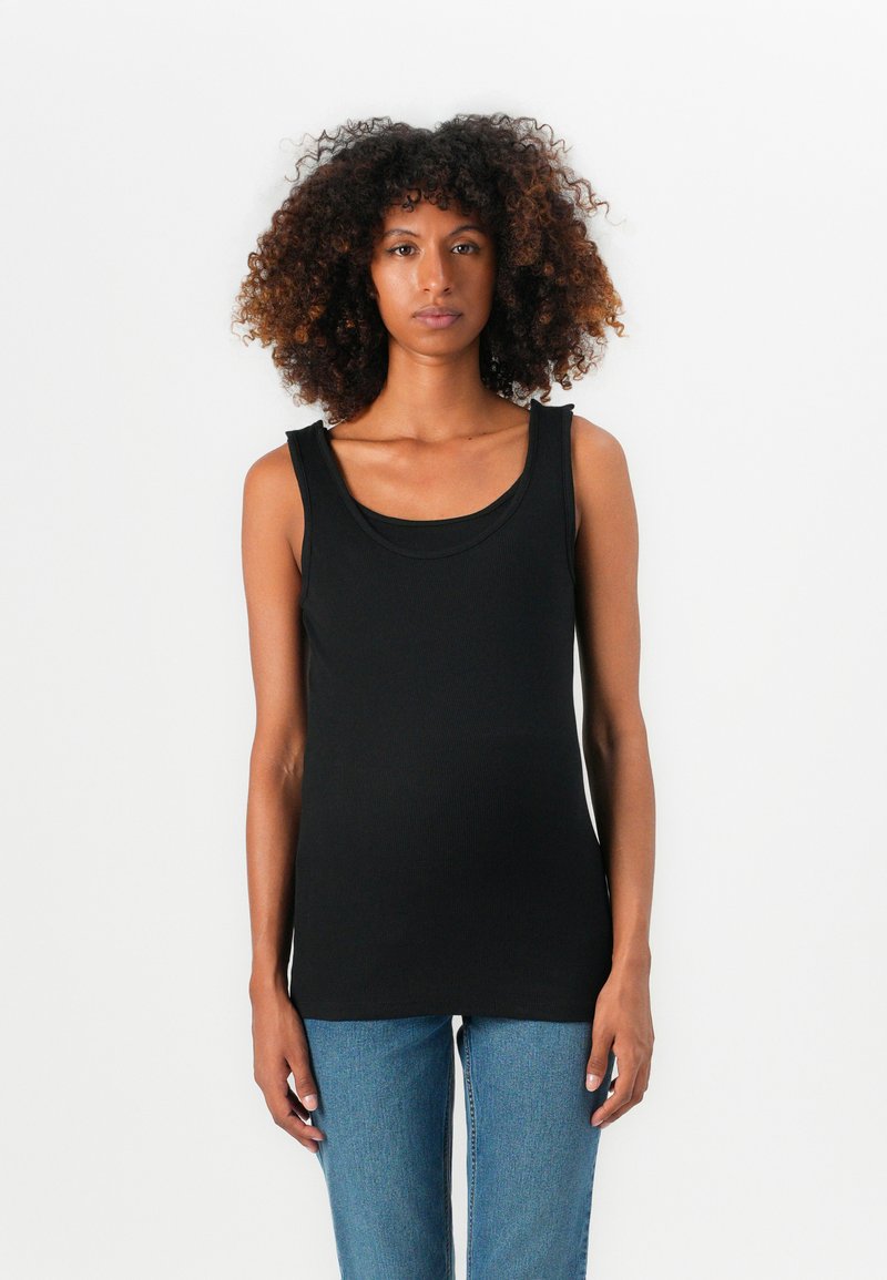 Top negro sin mangas con escote redondeado, hecho de tela acanalada. Combinado con unos vaqueros de denim azul claro. Diseño simple y color sólido.
