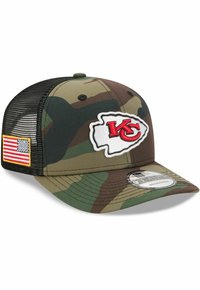 Camouflage-Mütze mit flachem Schirm, Netzrücken und einem auffälligen weißen Logo mit "KC" in Rot. Enthält ein kleines amerikanisches Flaggen-Patch an der Seite.