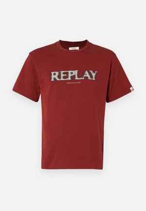 Camiseta de algodón roja con mangas cortas, que presenta un logotipo de texto blanco "REPLAY" en un estilo desgastado y "NINETEEN EIGHTYONE" debajo.